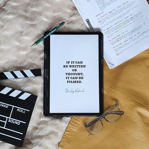 Digital Filmmaking Planner quote page beside a script with highlights and affirmation pen, be the difference and clapper board.